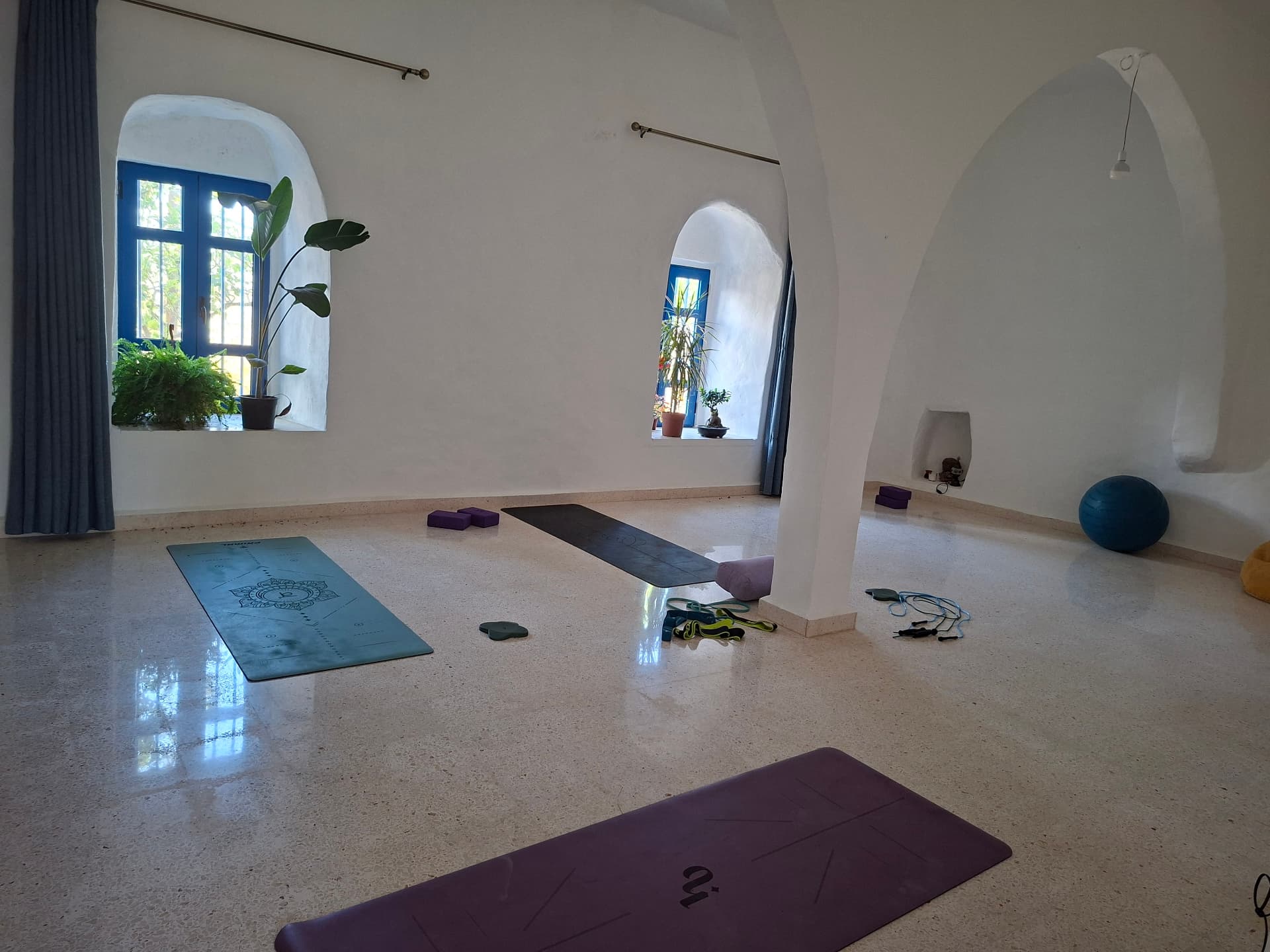 Bright arched yoga practice space in Batroun with mats, blocks and props laid out on a terrazzo floor